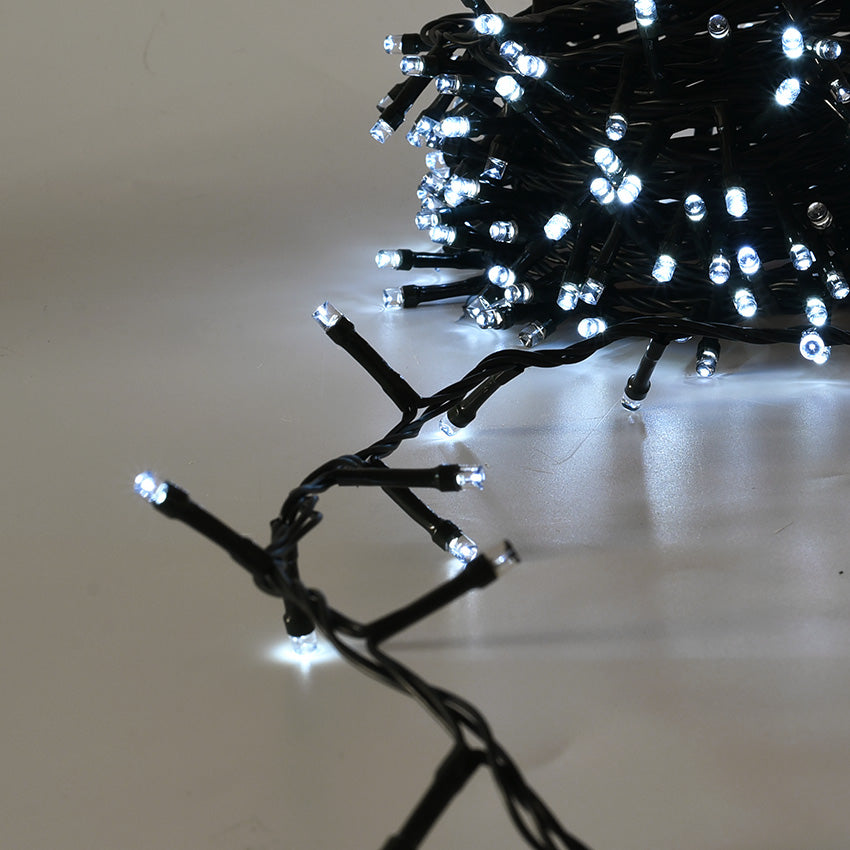 Dettaglio_Catena_Cluster_480_LED_Cavo_Verde_Arrotolata_a_Cerchio_Accesa_Luce_Bianca_su_Sfondo_Grigio